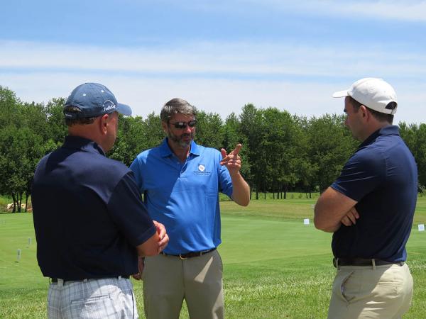 Mike Harrell, Ph.D., (center) talks turf with Alan Mark (left) of Jacklin Seed and Zach Nicoludis of the USGA Green Section. Photo by John Reitman