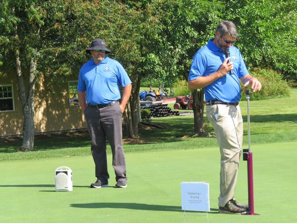 Travis Teuton, Ph.D., (left) and Mike Harrell, Ph.D., test the firmness of a green during this year's SETRC field day.