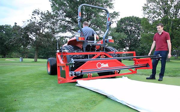 TarpDevil inventors Jordan Kitchen, shown here driving the tractor, and Ian Trepte, right, say his device can deploy and remove any permeable or impermeable greens cover.