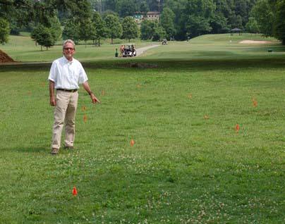 Ray Mock points to flags indicating locations of some of the 80-plus graves beneath an area near the No. 5 green at North Fulton Golf Course in Atlanta. Photo by the Buckhead View.