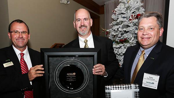 Georgia GCSA president Greg Burleson, CGCS, and Rocky Dreibrodt of Corbin Turf & Supply (right) present the chapters Superintendent of the Year award to Courtney Young, CGCS at Ansley Golf Club.