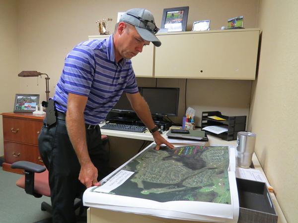 Rickey Craig, superintendent over all championship golf courses at The Villages, surveys a map of the property in September in preparation for Hurricane Irma. Photos by John Reitman.