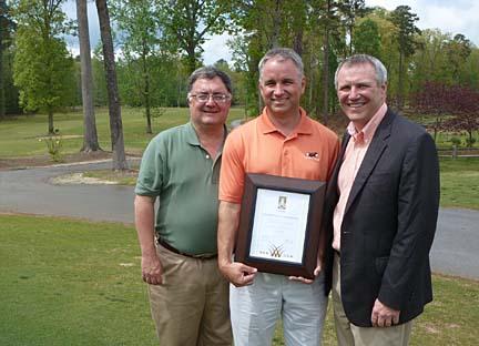Tennessee State Parks commissioner Bob Martineau, left, and Jacobsen president David Withers, right, congratulate Paul Carter on attaining environmental stewardship certification from the Golf Environment Organization.
