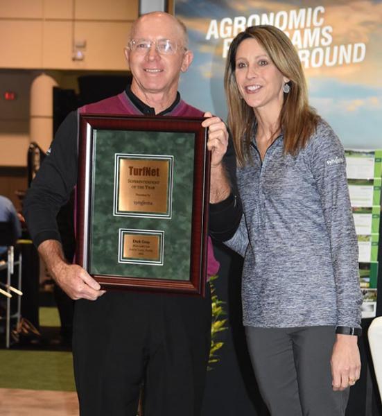 Stephanie Schwenke of Syngenta presents Dick Gray of PGA Golf Club in Port St. Lucie, Florida, with the TurfNet Superintendent of the Year Award.