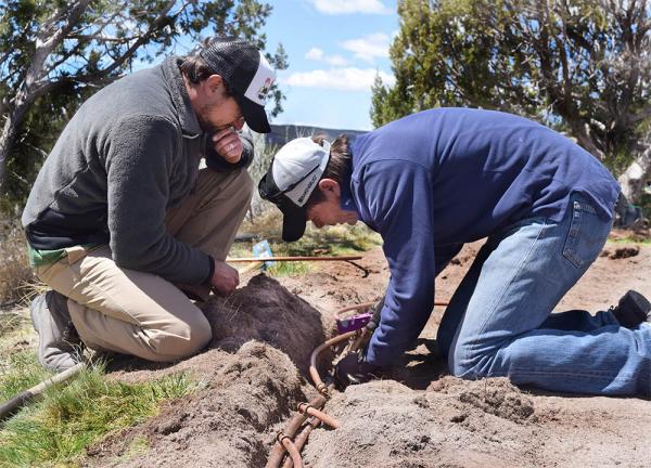 Bernd Leinaur, Ph.D., right, installs drip irrigation at Las Campanas golf course as Matteo Serena, Ph.D., left, looks on.